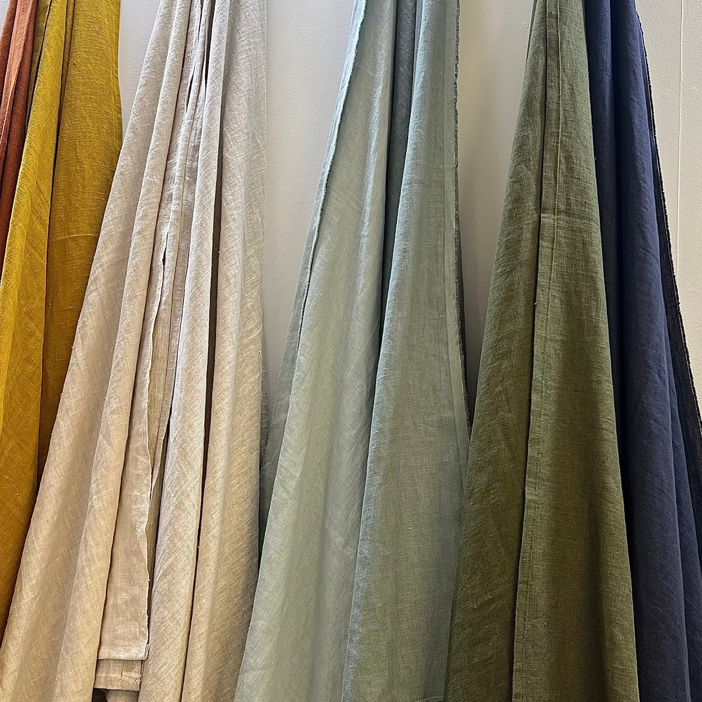 Collection of draped fabrics in various colors on a white background